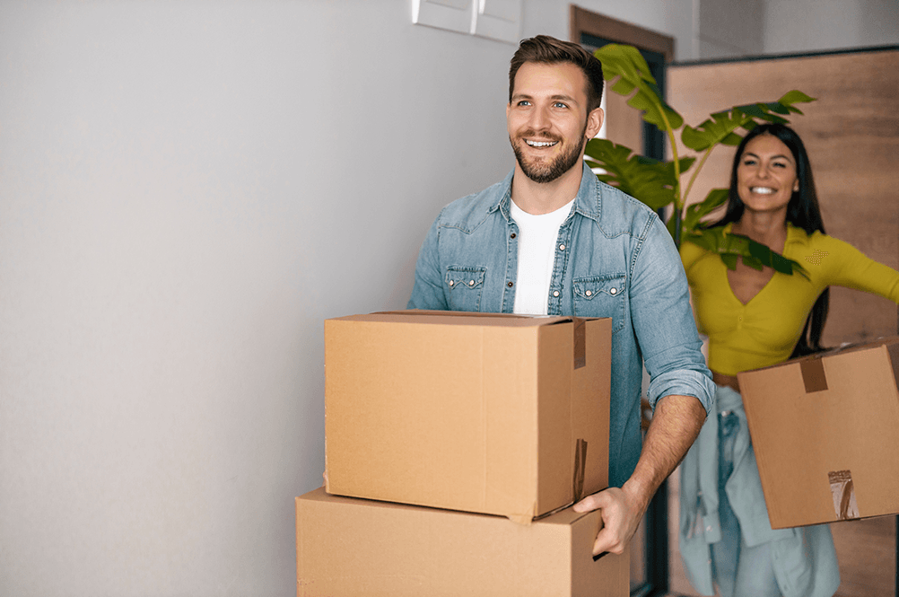 A couple sitting by unpacked boxes in a new house. Your Mortgage Tailored for You.