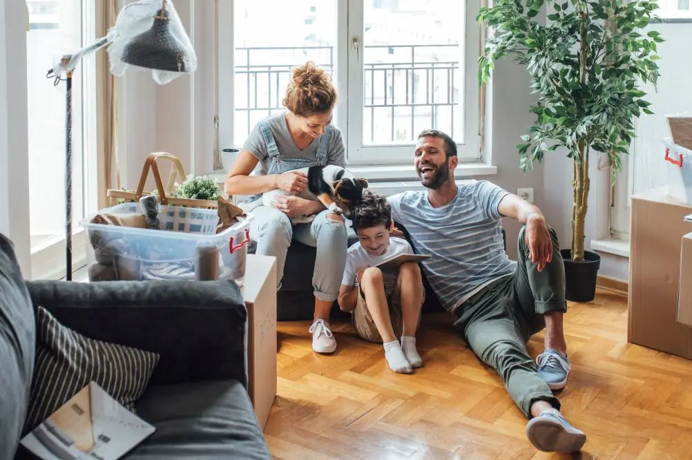 A couple sitting by unpacked boxes in a new house. Your Mortgage Tailored for You.