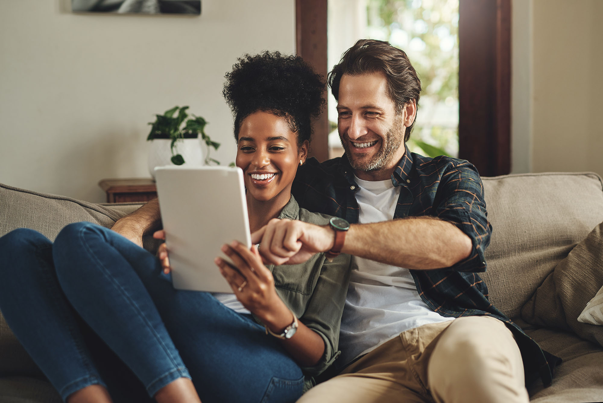 A couple smiling and look at a tablet, reflecting the security of full service banking.