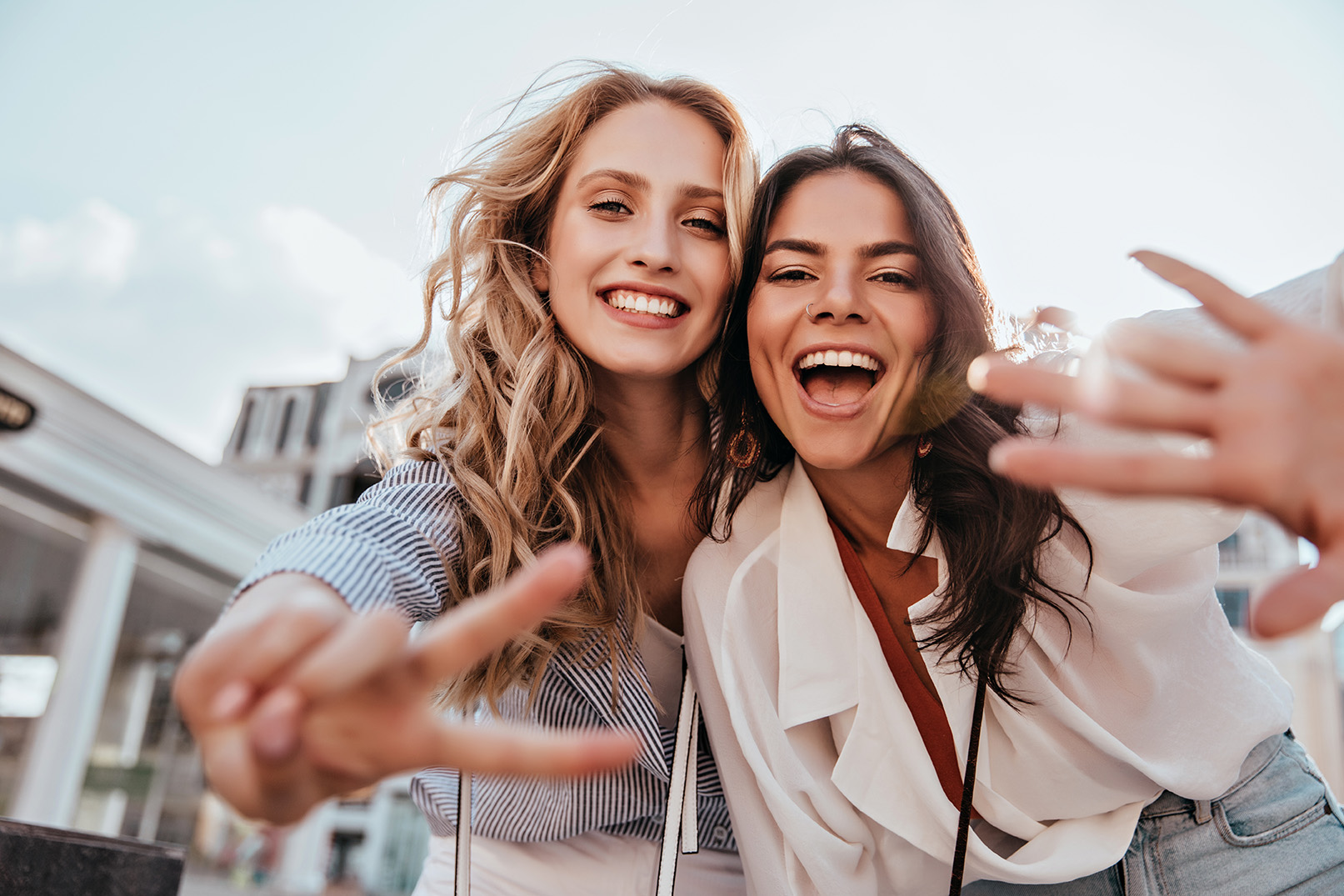 Two women posing for a selfie, reflecting sharing banking opportunities with friends.