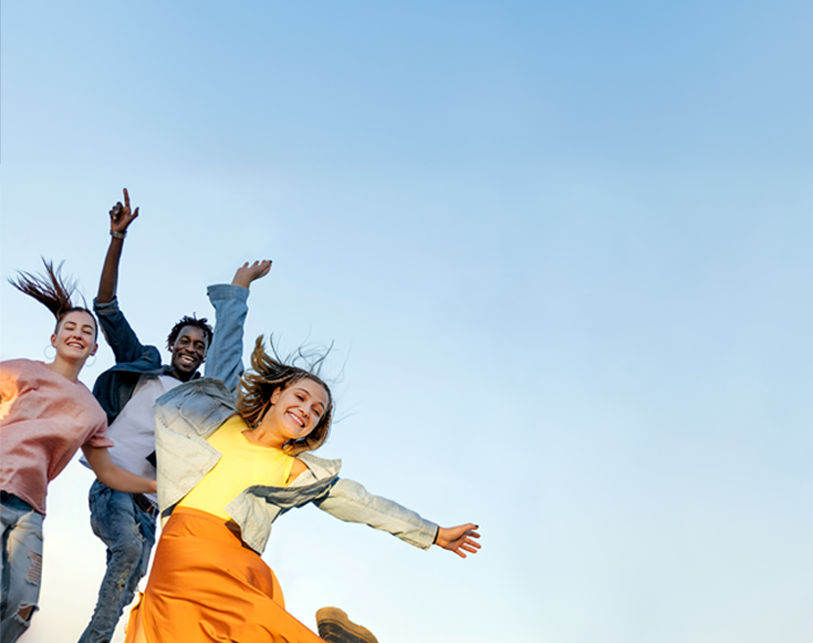 Students jumping in the sky, reflecting the start of a financial journey with a credit union that puts you first