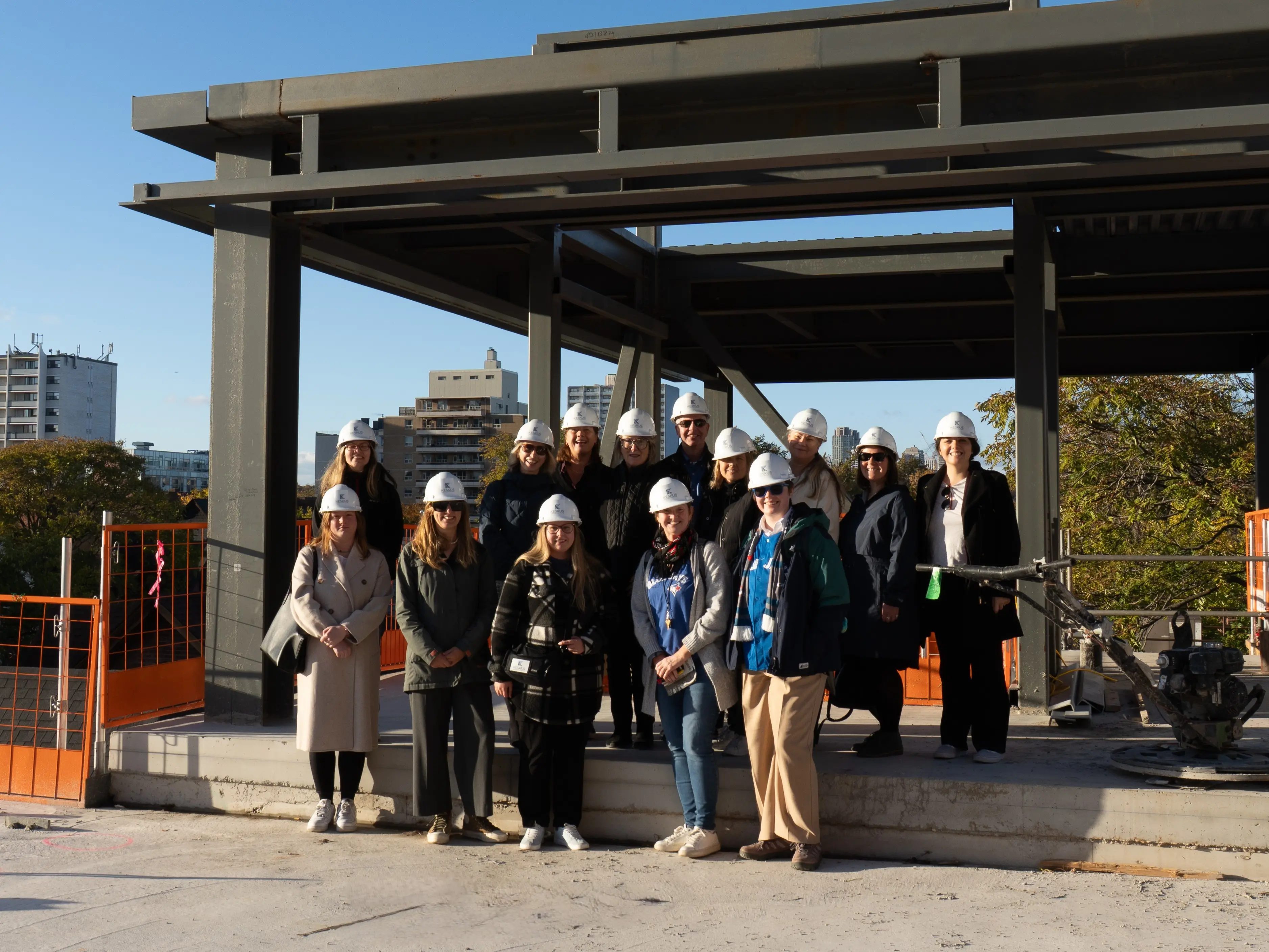 The Northern Birch Credit Union team standing for a photo in front of the frame of the KESKUS International Estonian Centre