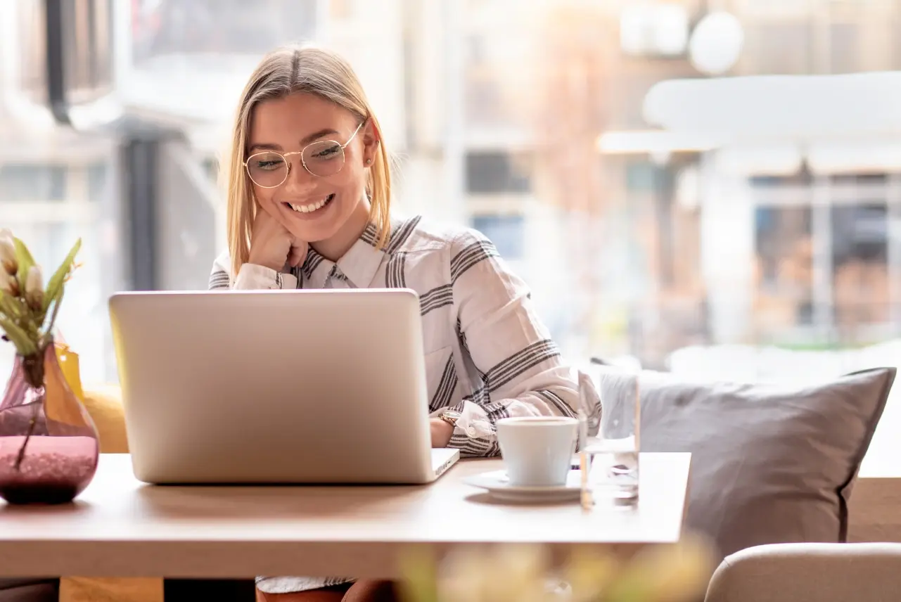 A young woman working on her laptop in a cafe