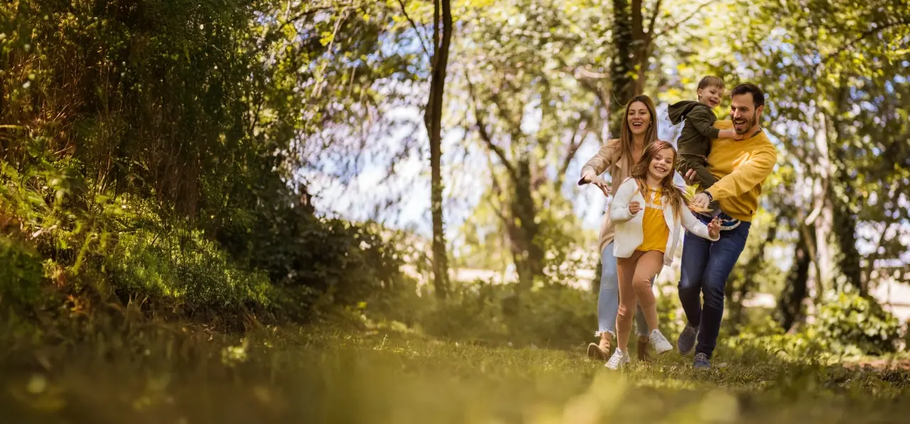 A young family enjoying time together under the trees on a summer day