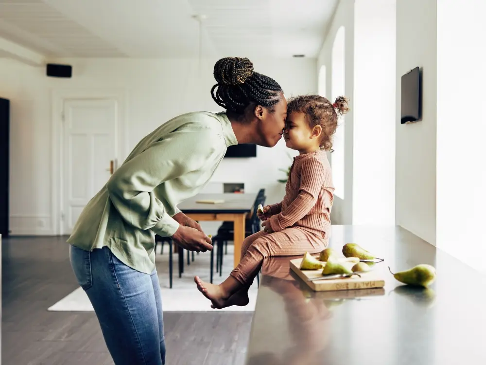 A mother playing with her daughter on the kitchen counter