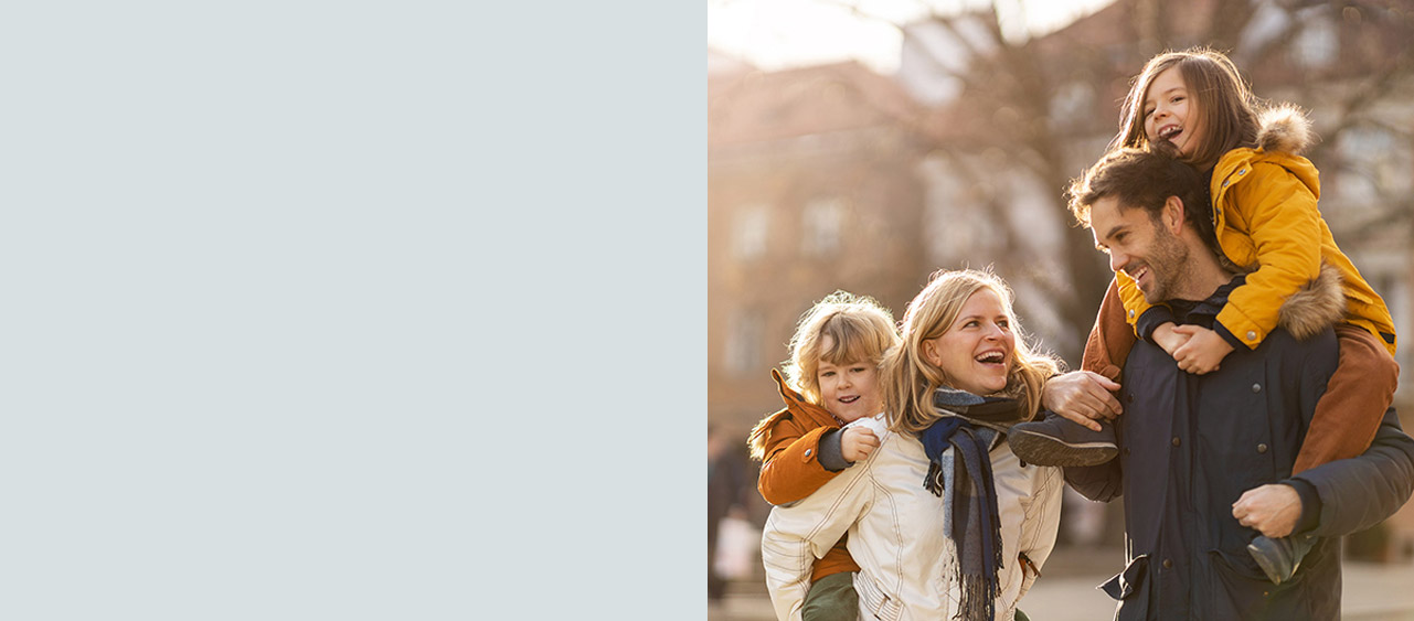 A picture of a family under falling orange leaves smiling, for the Early Bird TFSA Saver
