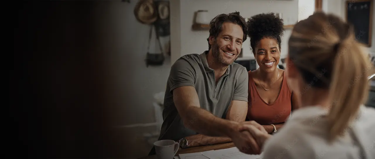 A couple shaking hands with an advisor offering a financial check-up