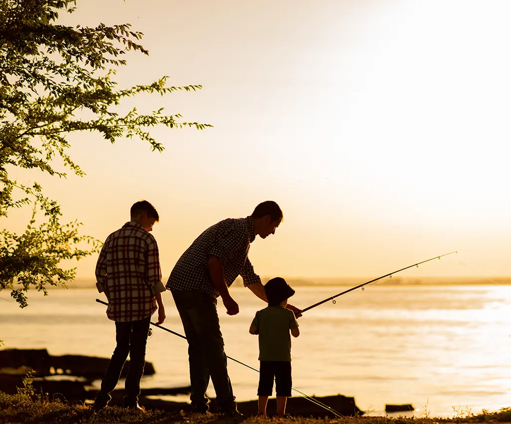 A dad teaching his sons to fish against a sunrise, reflecting Early Bird TFSA Saver